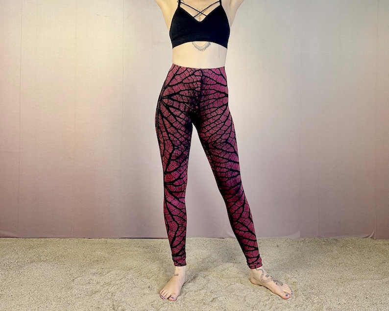 May include: Red and black patterned leggings with a leaf design. The leggings are high-waisted and have a tight fit.