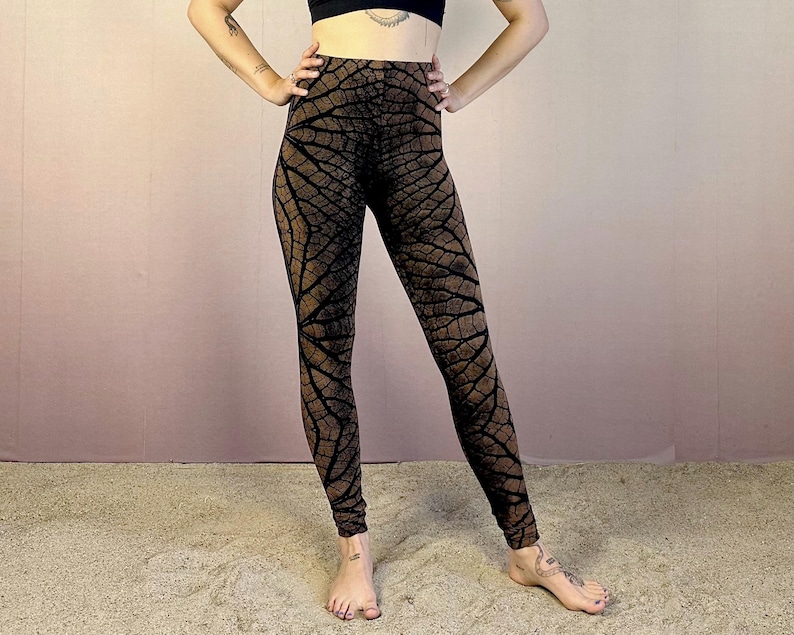 May include: Brown and black leggings with a leaf pattern. The leggings are fitted and have a high waist.