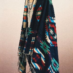 May include: A black and multi-colored woven shawl with fringe. The shawl features geometric patterns in shades of red, blue, green, and white.
