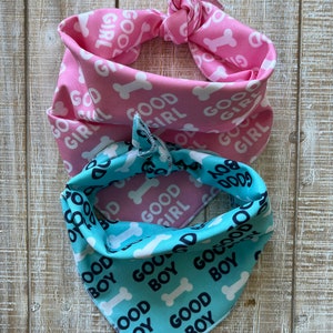 May include: Two dog bandanas, one pink with white "Good Girl" text and bone print, and one blue with black "Good Boy" text and bone print.