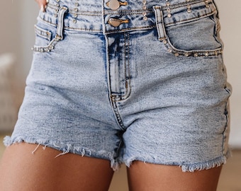 Shorts vaqueros de talle alto con bajo sin rematar y pedrería azul claro.