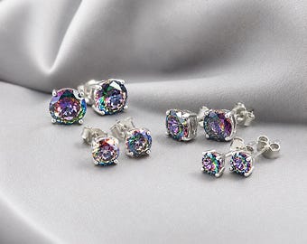 May include: Three pairs of round stud earrings featuring iridescent, multi-colored stones set in silver-toned metal prongs. Each earring has a post back closure, showcasing a spectrum of colors including purple, green, and blue hues.