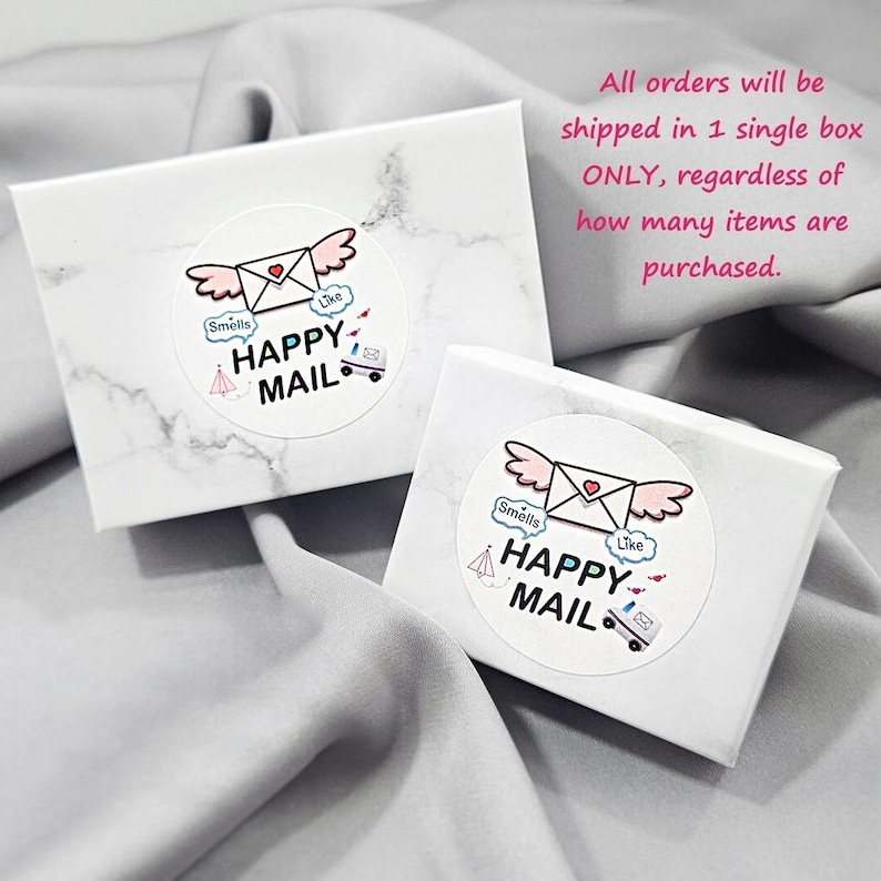 two white boxes with a marbled texture, each with a sticker that says "Happy Mail" and includes a heart and an envelope. The text above the boxes states that all orders will be shipped in a single box, regardless of how many items are purchased.