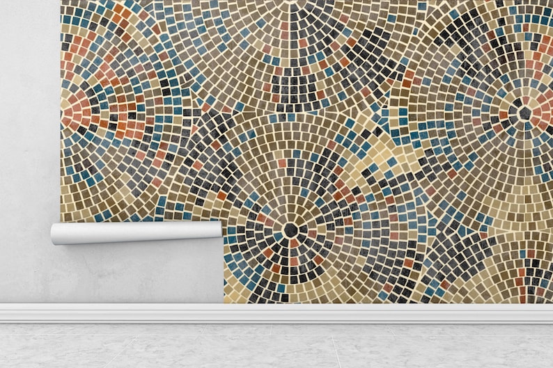May include: A close-up of a wallpaper with a geometric pattern of brown, blue, and red squares arranged in concentric circles. The wallpaper is peeling off the wall, revealing a white wall underneath.