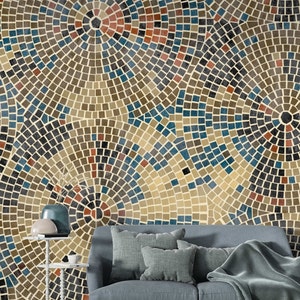 May include: A living room interior design with a blue couch and a throw blanket. The wall behind the couch is covered in a mosaic pattern wallpaper with blue, brown, and red tiles.
