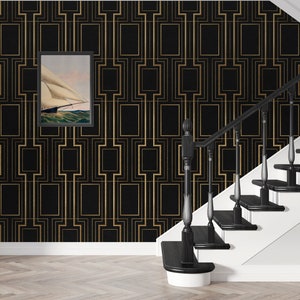 May include: Black and gold geometric wallpaper with a framed picture of a sailboat on a body of water. The wallpaper is on a wall with a black staircase.