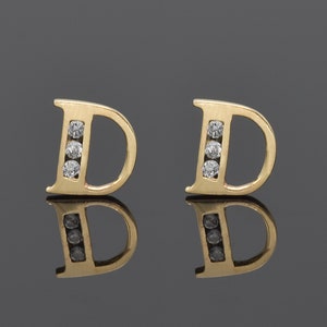 Aretes de oro macizo de 14k con inicial D y circonitas. Aretes tipo botón. Monograma inicial. Aretes con alfabeto. Se venden por unidad o combinados.