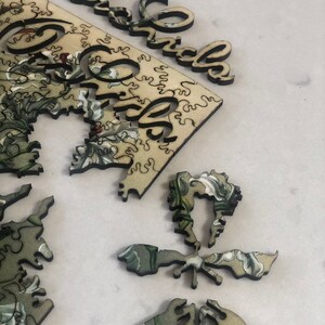 May include: A wooden jigsaw puzzle with a floral design and the word "Grandma" on the edge of the puzzle pieces.