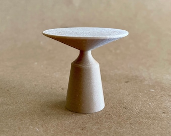 May include: A small, white, wooden table with a round top and a cone-shaped base.
