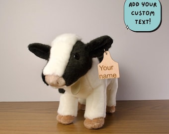 May include: Black and white plush cow toy with a brown tag that says "Your name".