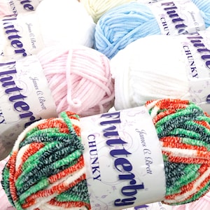 May include: A selection of colourful chunky yarn balls, including white, pink, blue, and a multi-coloured mix of green, red, and white. Each ball is labelled with "Flutterby CHUNKY" and "James C. Brett".