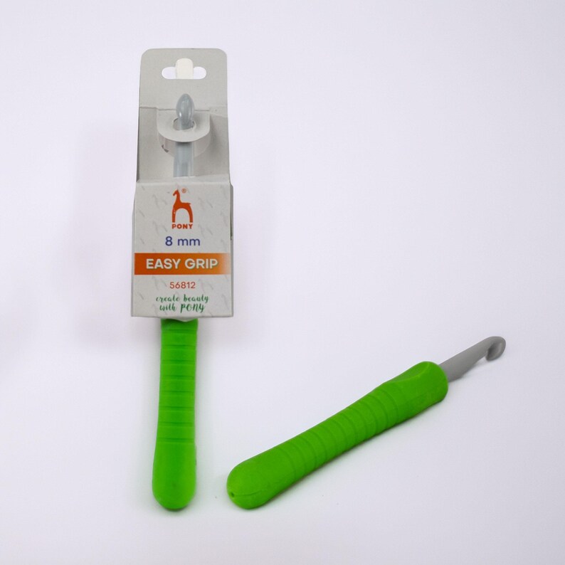 May include: A green and gray crochet hook with an 8 mm size, labeled "Easy Grip" by Pony. The hook has a green, textured handle and a gray hook end. The packaging includes the Pony logo and the text "create beauty with PONY."