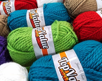 May include: A collection of colorful yarn skeins in various shades, including red, teal, green, and white. Each skein is labeled with "Top Value Super Chunky" and "James C. Brett". The image showcases a variety of yarn for knitting and crochet projects.