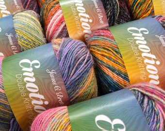 May include: Close-up of several skeins of James C. Brett Emotion Double Knitting yarn. The yarn is multi-colored with shades of pink, yellow, blue, orange, and purple. The labels are green with the word "Emotion" in white.