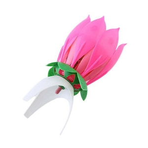 Może przedstawiać: Różowa i zielona świeca urodzinowa w kształcie kwiatu. Kwiat ma wiele warstw płatków i zieloną podstawę. Świeca jest zaprojektowana tak, aby otwierała się jak kwiat po zapaleniu.