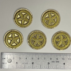 May include: Five gold embroidered patches with a five-pointed star design. The patches are circular and measure approximately 1 inch in diameter.