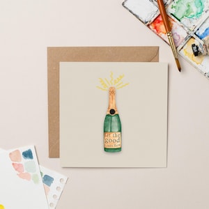 Tarjeta de felicitación con champán y lámina dorada