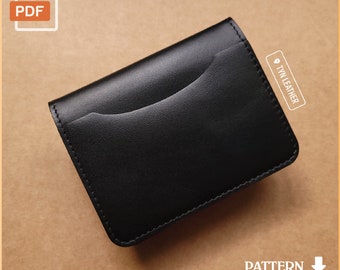May include: Black leather wallet with a single pocket and a stitched edge. The wallet is laying on a brown surface. The text "TYN LEATHER" is visible on the wallet.