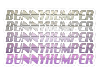 Op de afbeelding: Een sticker met het woord "BUNNYHUMPER" herhaald in een gestapeld ontwerp. De tekst verloopt van lichtgrijs naar paars, met een witte rand. De sticker heeft een glanzende afwerking.