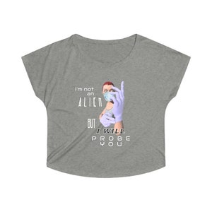 May include: Grey t-shirt featuring a cartoon image of a person wearing a face mask and gloves. The text on the shirt reads "I'm not an alien but I will probe you."