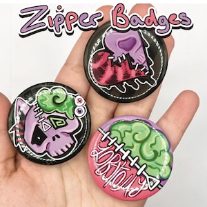 May include: Three round, black-rimmed zipper badges with colorful, cartoonish designs. One features a purple skull with green slime, another a pink heart with red stripes, and the last a green brain with text. The text "Zipper Badges" is above.