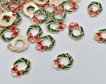 May include: Gold-toned metal wreath charms with green enamel leaves and red bow accents. These small charms are designed with a loop for easy attachment, perfect for jewelry making or holiday crafts.
