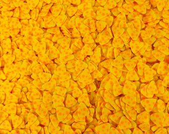 Puede incluir: Una gran cantidad de sprinkles amarillos en forma de triángulo con pequeños lunares naranjas.