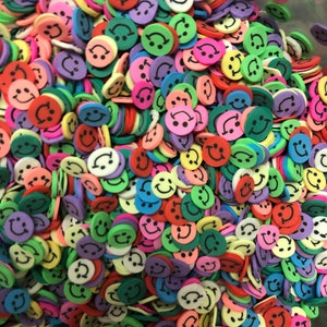 May include: A large pile of colorful smiley face sprinkles. The sprinkles are made of foam and are in various colors, including red, yellow, green, blue, purple, and pink.