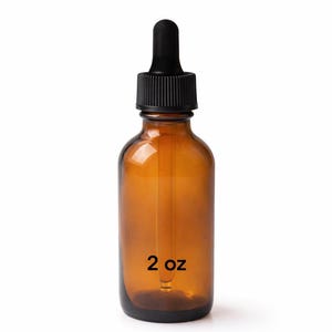 Op de afbeelding: Amberkleurige glazen fles met een zwarte druppelaar en dop. De fles heeft een inhoud van 60 ml, aangegeven door de tekst op de voorkant. Ontworpen voor het bewaren van vloeistoffen.