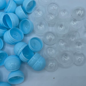 Puede incluir: Una colección de mitades de huevos de Pascua de plástico azul claro y mitades de huevos de Pascua de plástico transparente.