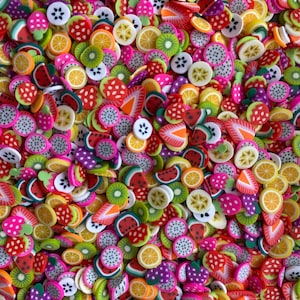 Peut inclure: Un assortiment de breloques en pâte polymère de différentes formes de fruits, notamment des fraises, des tranches de pastèque, des tranches de kiwi, des citrons et des tranches de fruit du dragon.