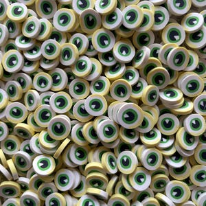 May include: A large pile of small, round, yellow and white eye-shaped charms with green pupils. The charms are made of polymer clay and are perfect for adding a spooky touch to crafts.
