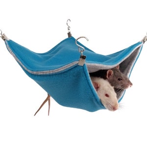 May include: A blue hanging hammock for small pets, such as rats, with two rats inside. The hammock is made of soft fleece and has a gray trim. It is suspended from the ceiling by two silver hooks.