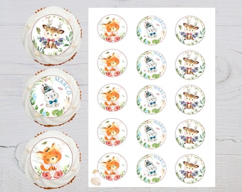 Pode incluir: Uma folha de toppers para cupcakes com vários desenhos de animais da floresta. Os toppers incluem um veado, uma raposa e um coelho. Os toppers são todos em estilo aquarela e têm um fundo azul claro. O texto "MARCO" está impresso em alguns dos toppers.