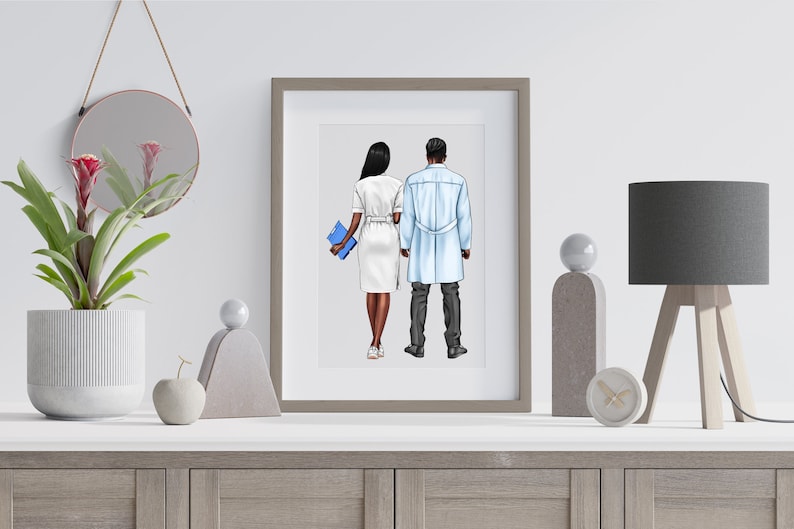 Puede incluir: Impresi&oacute;n art&iacute;stica enmarcada que muestra a un m&eacute;dico y una enfermera de espaldas. La enfermera viste un vestido blanco y sostiene una carpeta azul. El m&eacute;dico lleva una bata azul claro. La impresi&oacute;n se exhibe en una pared blanca.