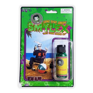 Puede incluir: Un kit de muestra de espuma de baño Smylex en empaque blíster. La tarjeta presenta un fondo verde con un gráfico de una persona con traje en una playa. La botella es verde con una etiqueta amarilla que muestra una cara y el texto Relaxing Bath Foam.