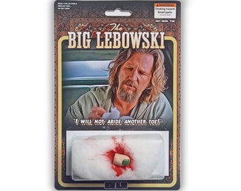 Könnte beinhalten: Sammelobjekt aus "The Big Lebowski". Die Verpackung zeigt ein Foto des Dude und den Spruch "I WILL NOT ABIDE ANOTHER TOE!". Enthält eine "HOT REAL TOE" Requisite mit Kunstblut.