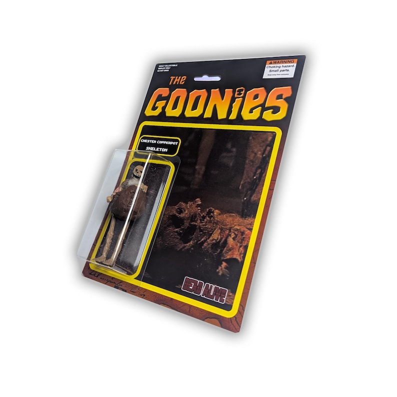 May include: A vintage action figure of the Chester Copperpot Skeleton from the movie "The Goonies." The packaging is black and yellow with the movie title in large, bold letters. The figure is encased in a clear plastic bubble.