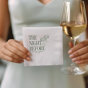 K&ouml;nnte beinhalten: Eine quadratische wei&szlig;e Papierserviette mit dunkelgr&uuml;nem Aufdruck THE NIGHT BEFORE, begleitet von einer Strichzeichnung zweier Cocktailgl&auml;ser sowie den Namen Gabriella und Jackson mit dem Datum 03.27.2026 darunter gedruckt.