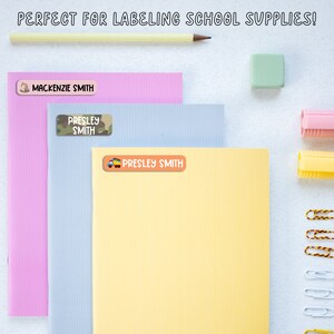 May include: Three colorful folders with personalized labels. The labels feature different designs and the names "Mackenzie Smith", "Presley Smith", and "Presley Smith".