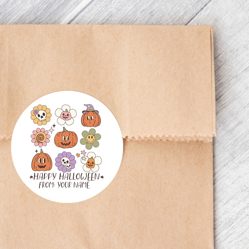 Op de afbeelding: Een ronde witte sticker met een Halloween-thema. Het bevat verschillende illustraties, waaronder pompoenen, bloemen en schedels. De tekst op de sticker luidt "Happy Halloween" en "From: Your Name".