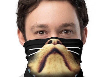 May include: A black face mask with a cat face graphic. The cat's nose and whiskers are white. The text "The Fuzz" is printed in blue on the mask.