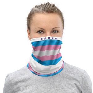 May include: A face mask with a transgender pride flag design. The mask is white with blue and pink stripes and the text "trans" in purple letters.