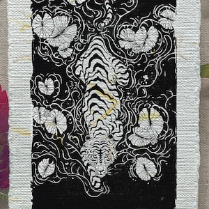 Linoleografia di tigre su carta fatta a mano con petali gialli, tigre a caccia di predatori selvatici, grande cacciatore di felini in uno stagno di ninfee, stampa artistica nera