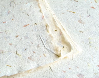 Papier artisanal fait main avec oignon orange et herbe verte, bords texturés naturels Khadi produit de manière éthique avec fibres végétales visibles