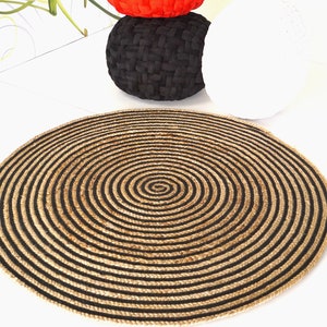Peut inclure: Un tapis rond en jute avec des rayures noires et naturelles en jute en forme de spirale.