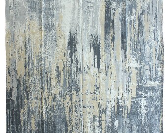 Op de afbeelding: Abstract vloerkleed met een distressed design. Het vloerkleed heeft een mix van grijze, beige en witte tinten, waardoor een textuurrijk, schilderachtig effect ontstaat. Het ontwerp heeft verticale en horizontale penseelstreekachtige patronen.