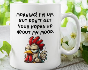 May include: White ceramic coffee mug with a cartoon rooster illustration and the text "MORNING! I'M UP, BUT DON'T GET YOUR HOPES UP ABOUT MY MOOD."