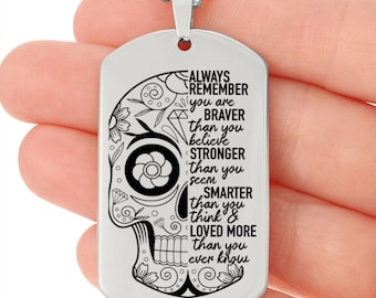 May include: Silver dog tag necklace with a black and white sugar skull design and the text "ALWAYS REMEMBER you are BRAVER than you believe STRONGER than you seem SMARTER than you think & LOVED MORE than you ever know"