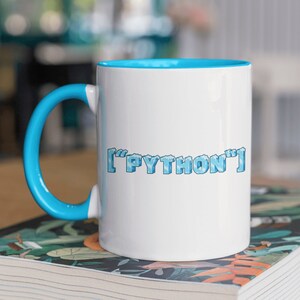 May include: White ceramic mug with a blue rim and handle. The mug has a blue and white pixelated design that says "['PYTHON']" on the front.
